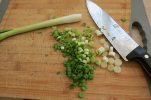 For the spinach lemon lasagna, chop the spring onions