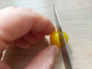 Cutting a tomato round the middle