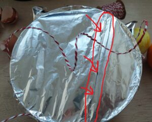 Bowl of pudding covered with foil in which a crease has been folded