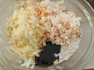 Dry ingredients for Christmas Pudding in a bowl, plus suet, apple and treacle