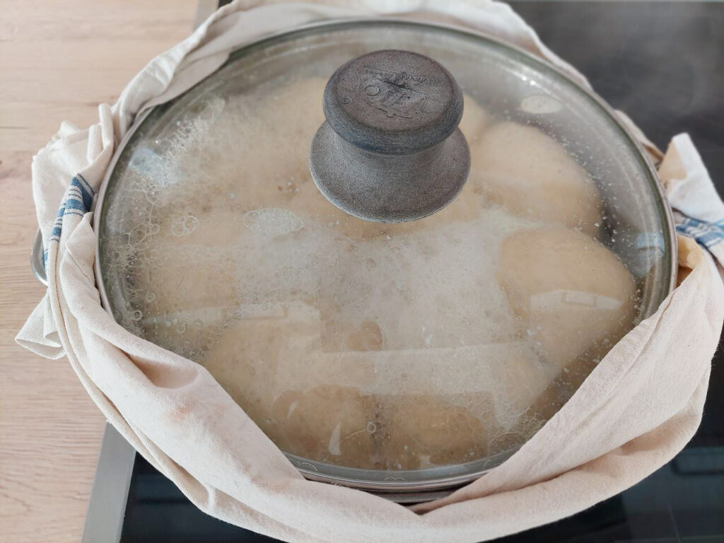 Slowly cooking Dampfnudeln in a pot with closed lid
