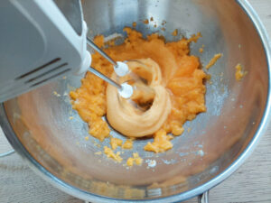 Electric mixer whisking sugar and egg yolks together