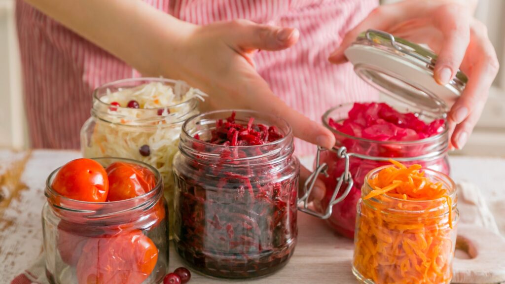 Jars with different ferments, a lady in the background closing one jar