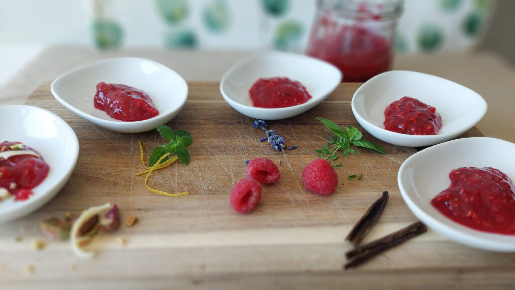 dishes with different raspberry jams, the additional ingredients lined in the foreground