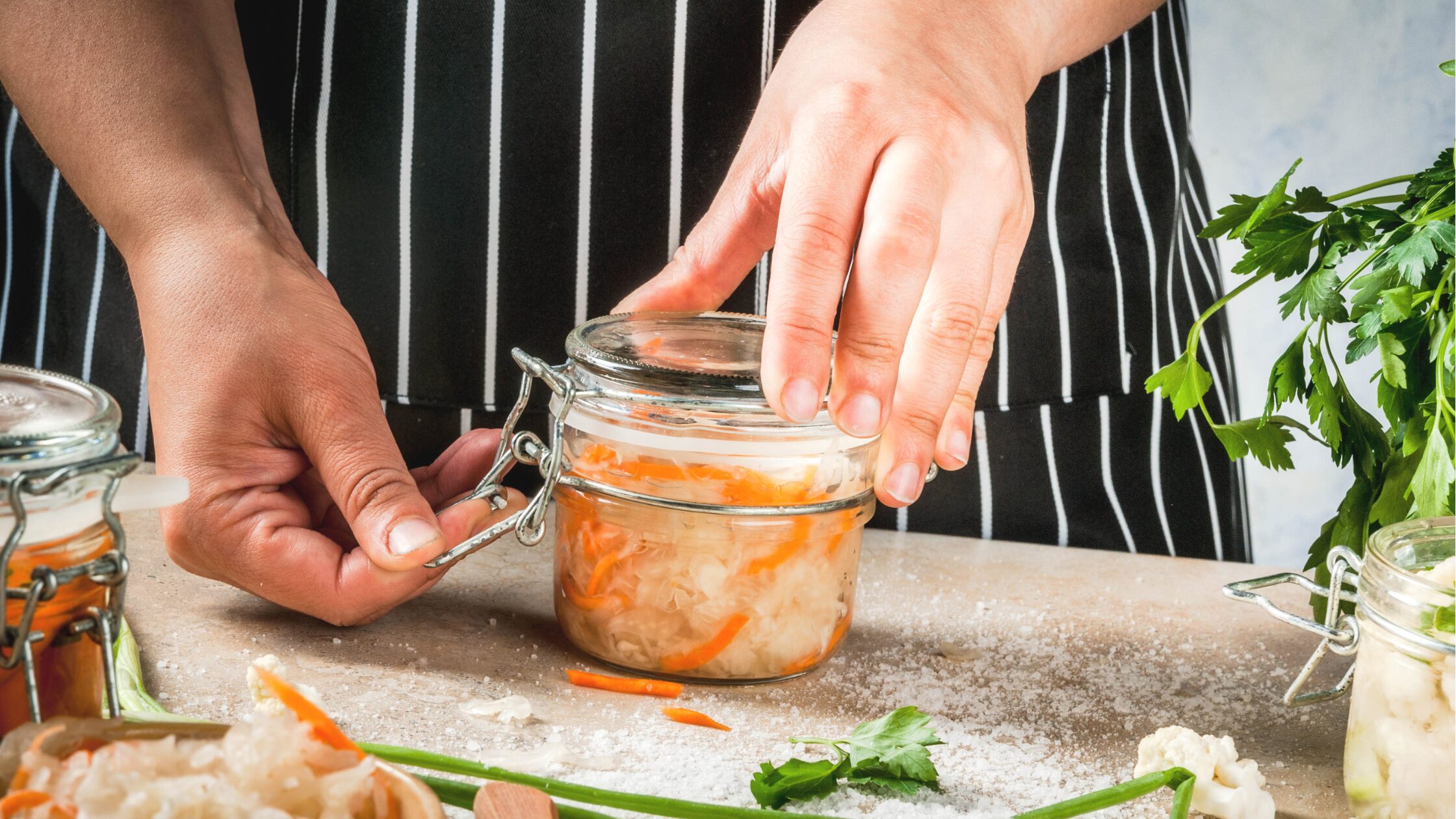 Fermentation safety A woman closing a jar of fermented vegetables
